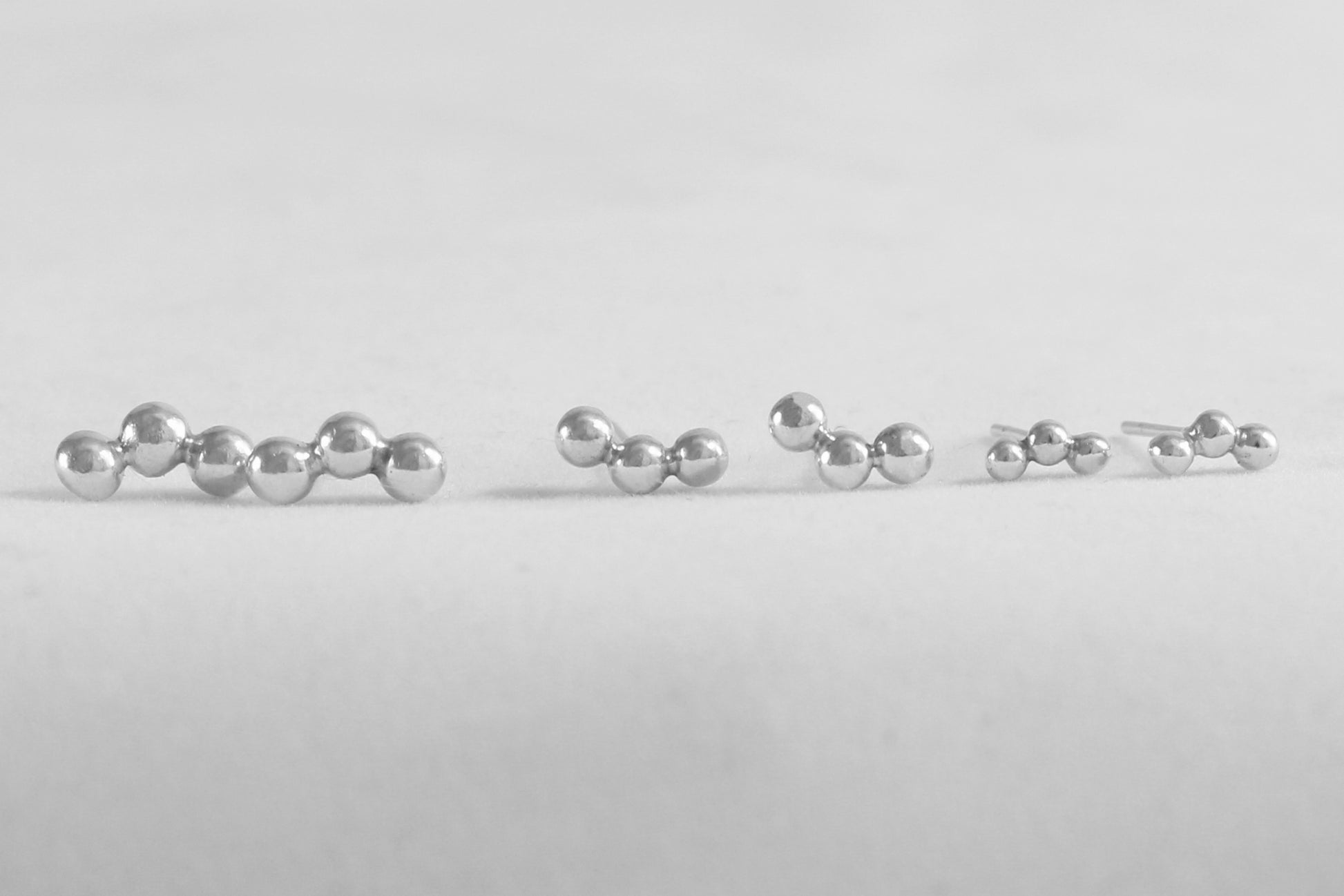 Sterling silver studs with three bubbles along a curve.