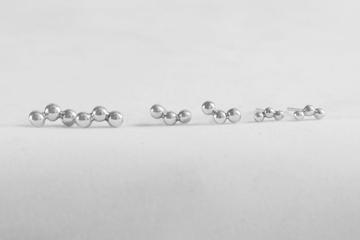 Sterling silver studs with three bubbles along a curve.