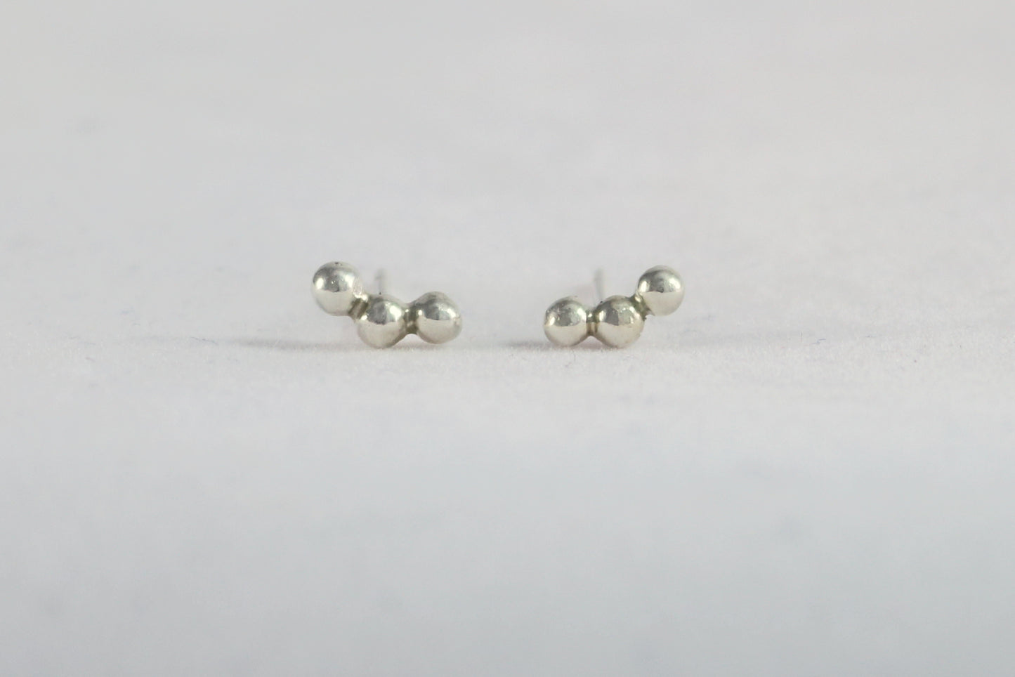 Sterling silver studs with three bubbles along a curve.