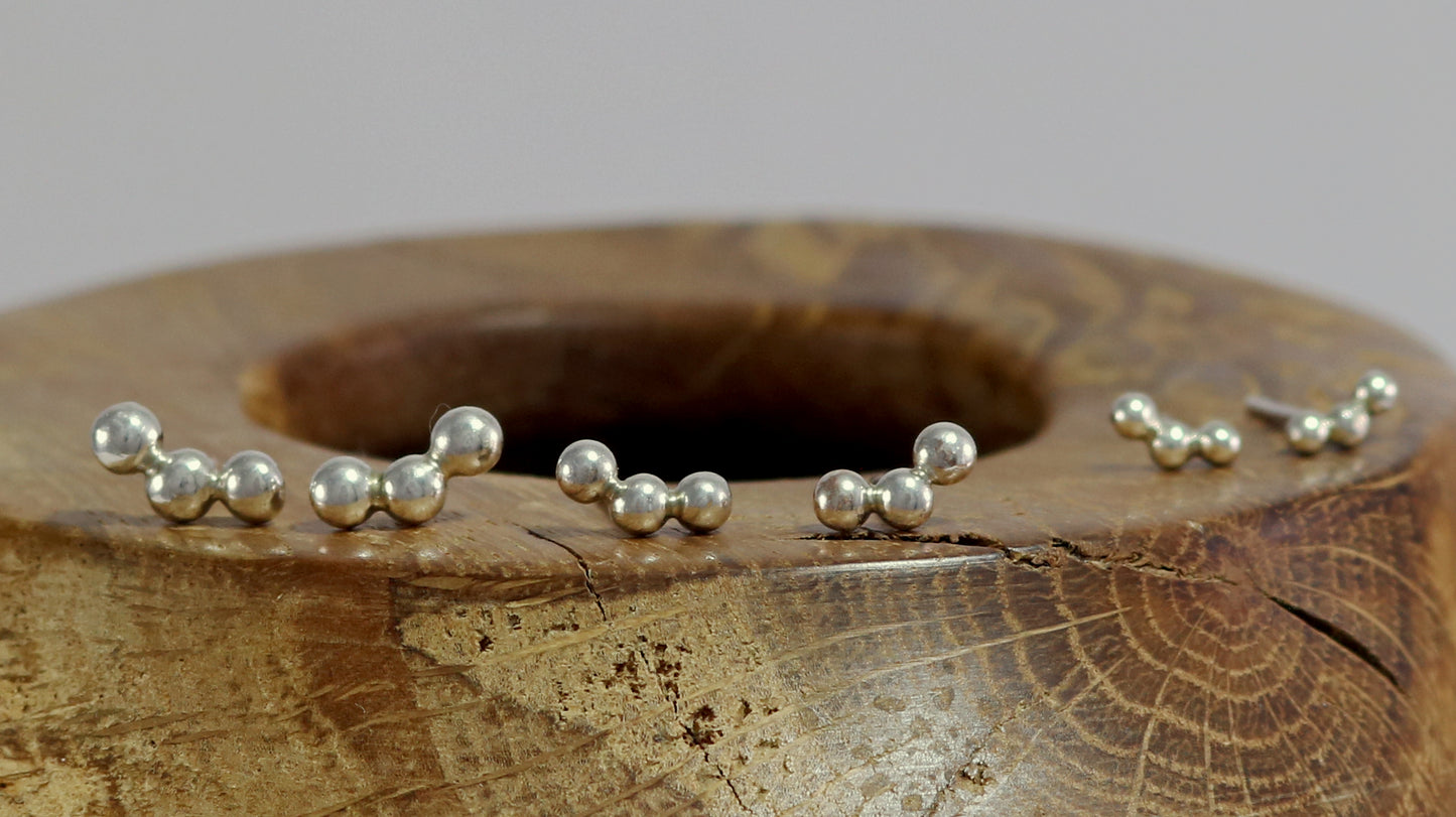 Sterling silver studs with three bubbles along a curve.