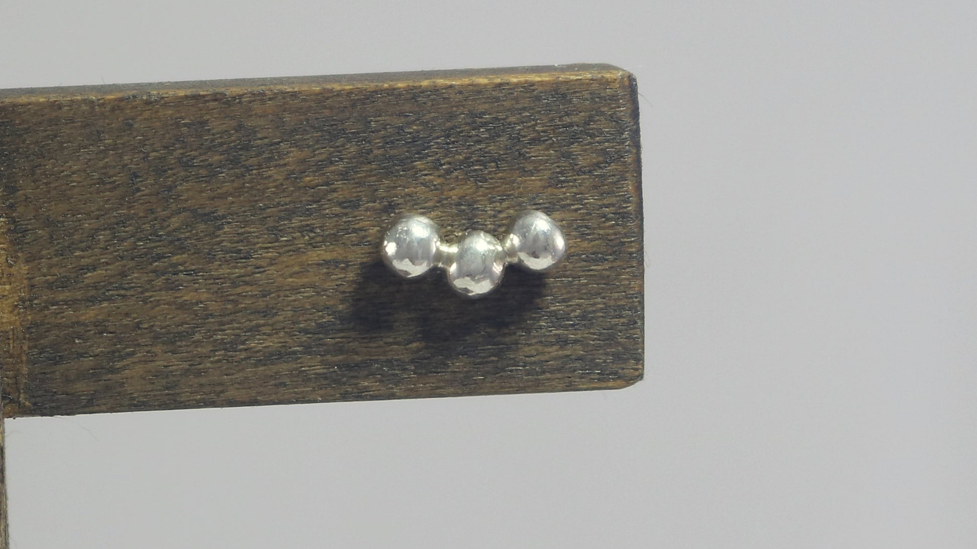 Sterling silver studs with three bubbles along a curve.