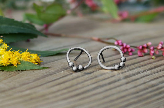 Sterling silver circle stud earrings with three silver bubbles at the bottom.