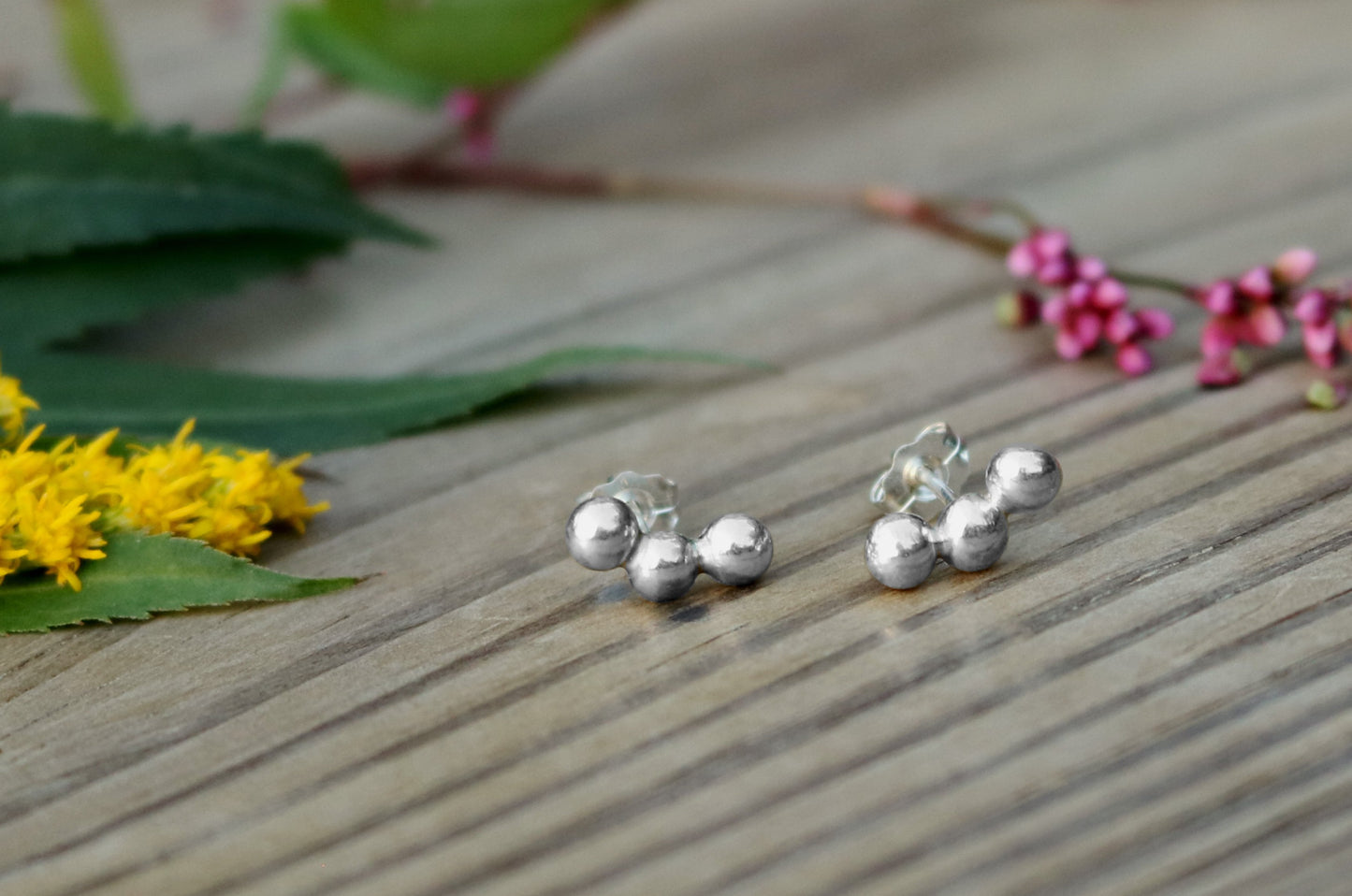 Sterling silver studs with three bubbles along a curve.