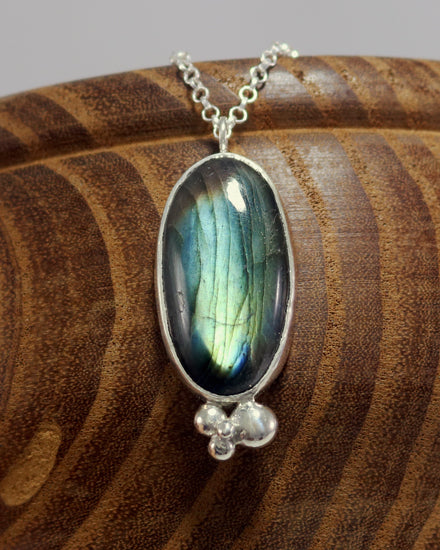 Oval natural Labradorite gemstone set in sterling silver bezel with 4 bubble cluster accent on a sterling silver chain.