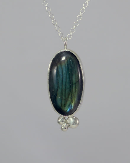 Oval natural Labradorite gemstone set in sterling silver bezel with 4 bubble cluster accent on a sterling silver chain.