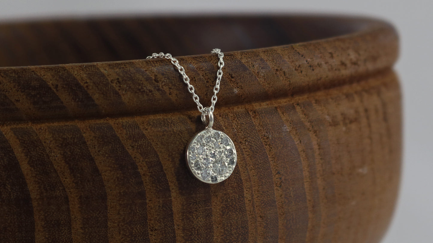 Sterling silver disc charm, pave set with diamonds on a sterling silver chain.