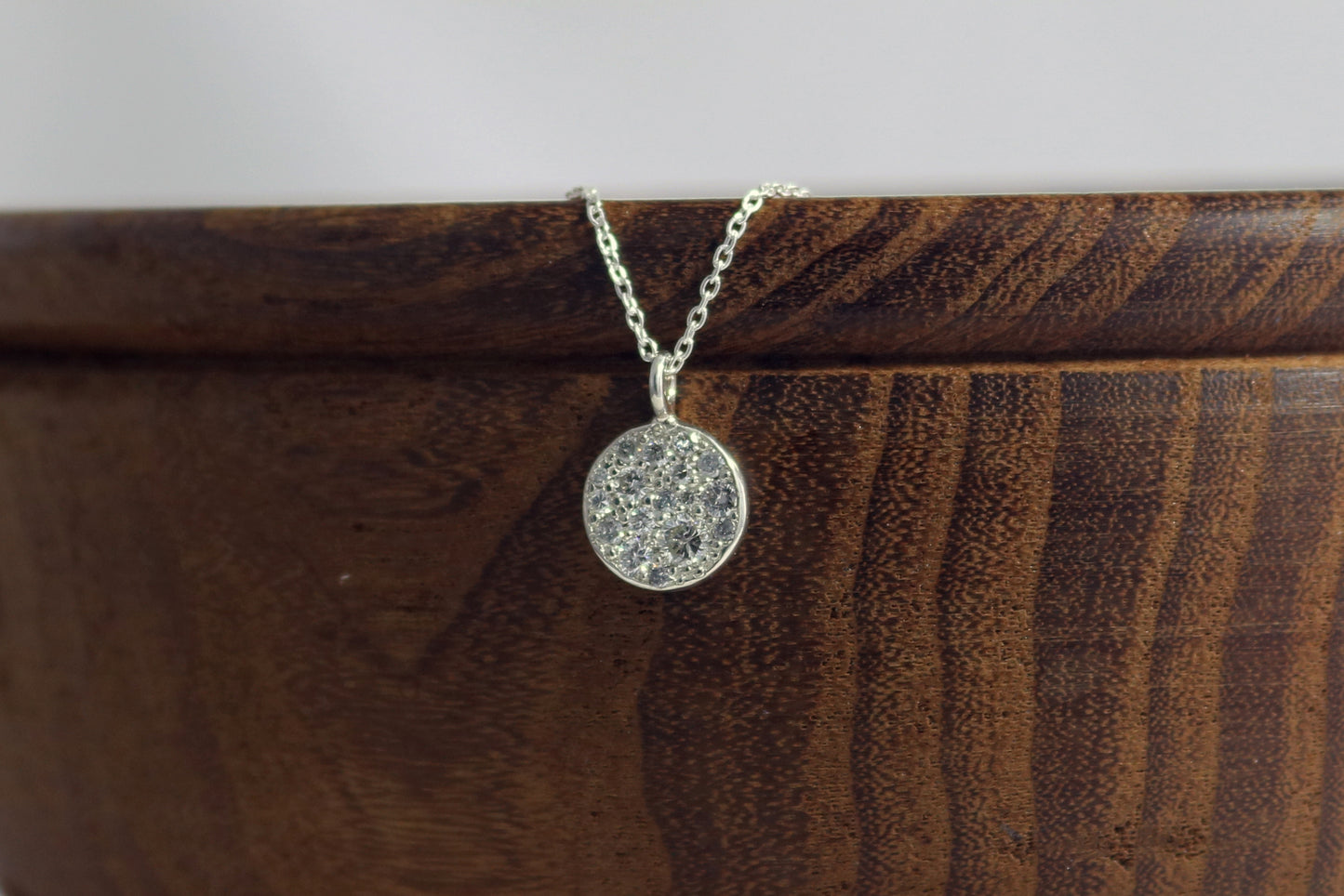 Sterling silver disc charm, pave set with diamonds on a sterling silver chain.