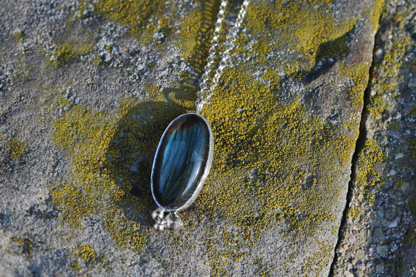 Oval natural Labradorite gemstone set in sterling silver bezel with 4 bubble cluster accent on a sterling silver chain.