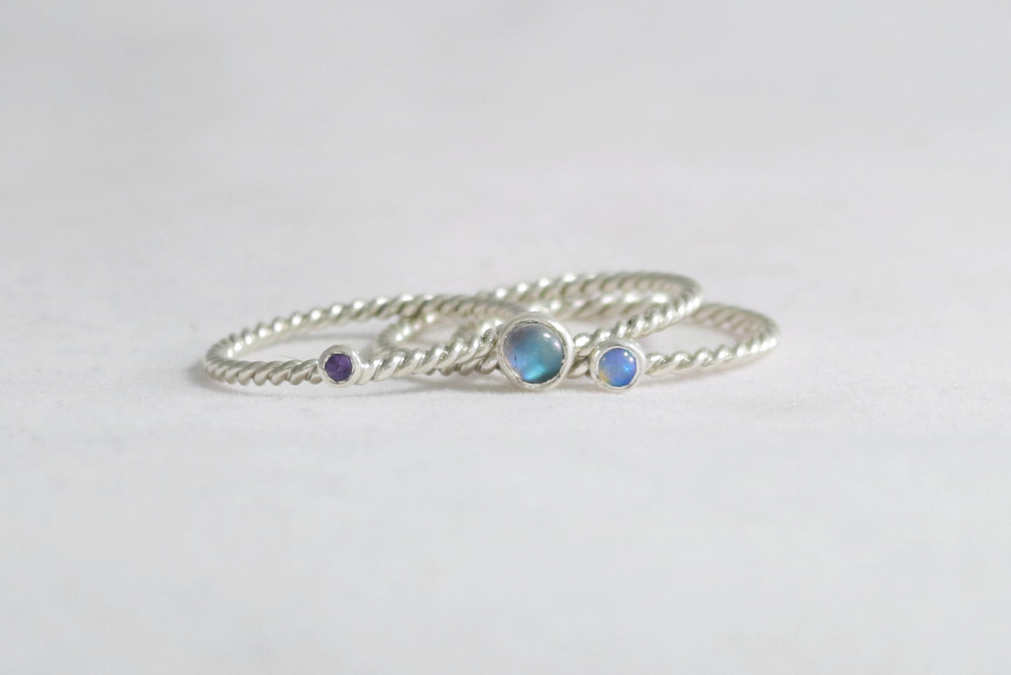 Round natural gemstone set in a sterling silver bezel on a twisted sterling silver ring band.