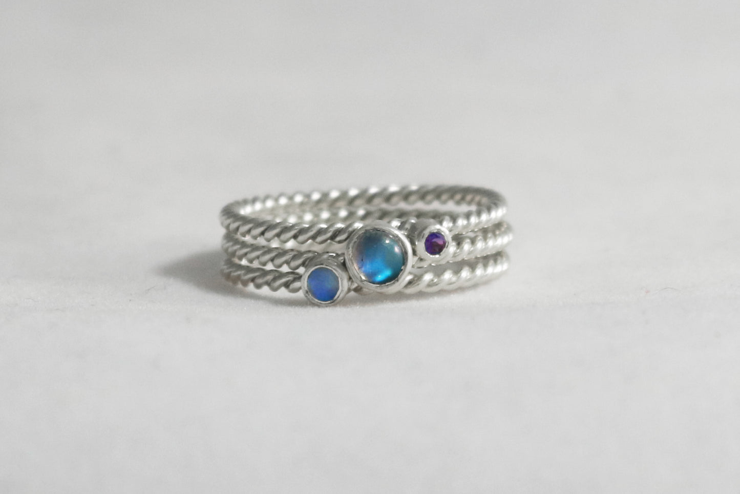 Round natural gemstone set in a sterling silver bezel on a twisted sterling silver ring band.