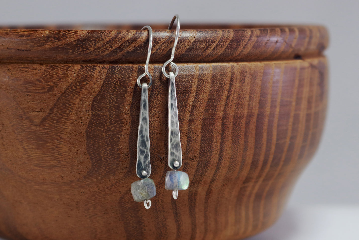 A hand forged, textured, sterling silver, elongated drop with a hanging labradorite bead.