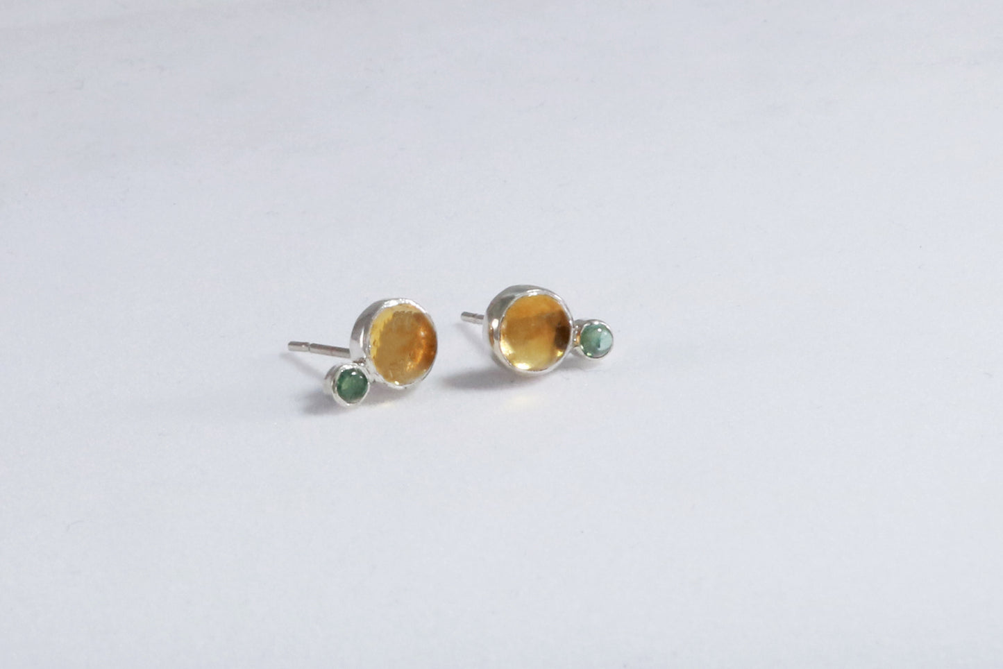 Stud earrings, natural round citrine gemstones set in sterling silver bezels with a small natural green tourmaline bezel set below.