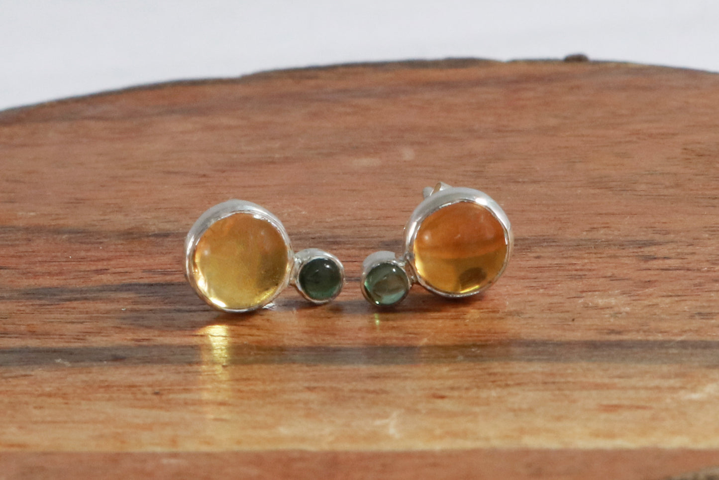 Stud earrings, natural round citrine gemstones set in sterling silver bezels with a small natural green tourmaline bezel set below.
