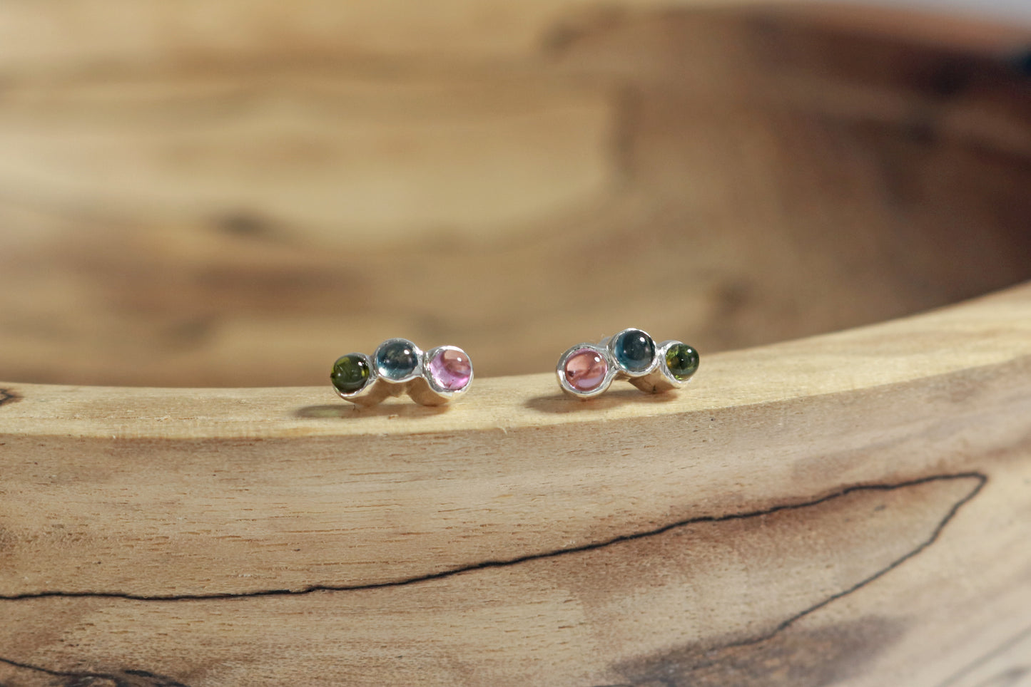 Stud earrings, 3 round natural gemstones set in sterling silver bezels on a curve.