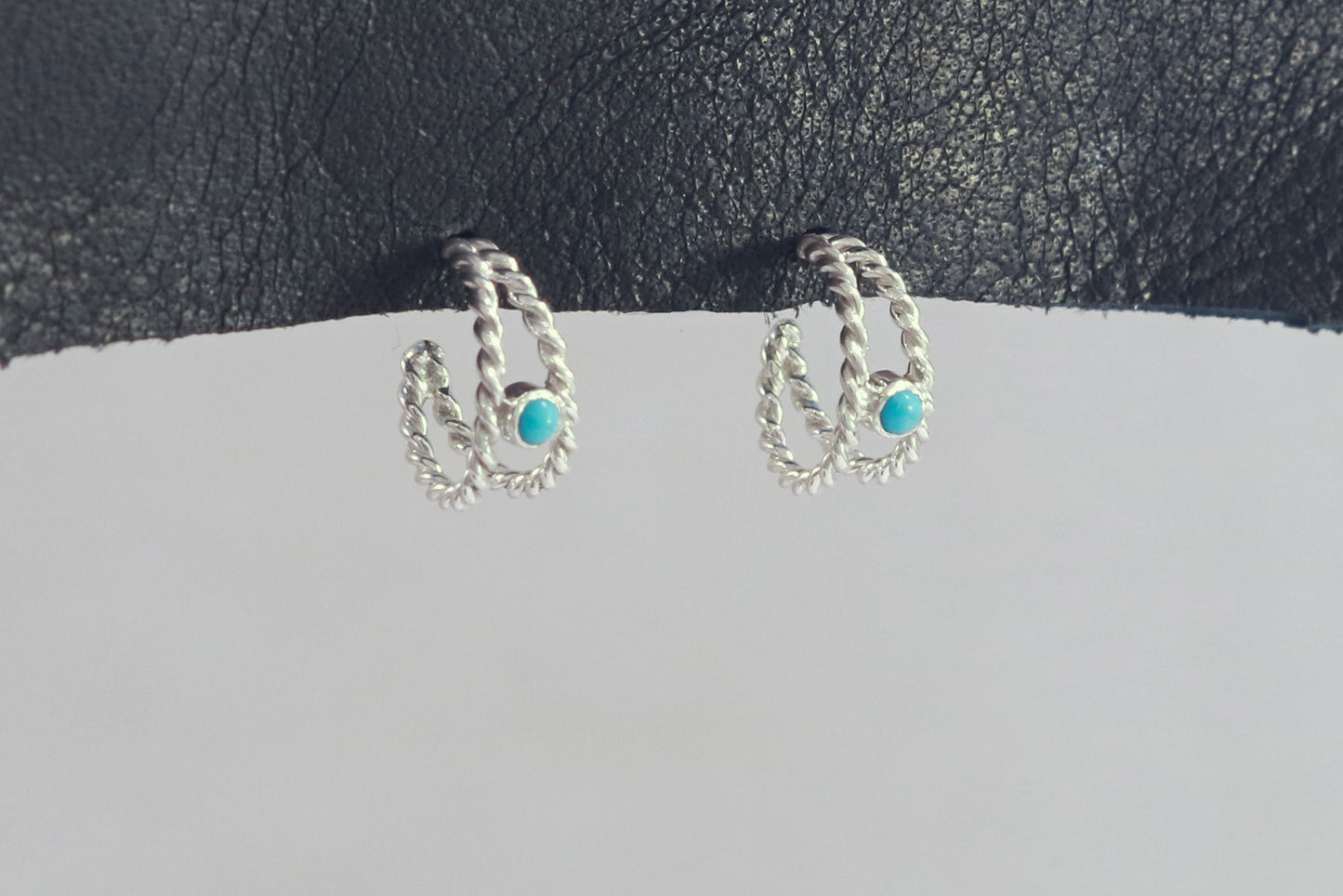 Small hoop huggie earrings made from 2 twisted sterling silver hoops with a round natural gemstone.
