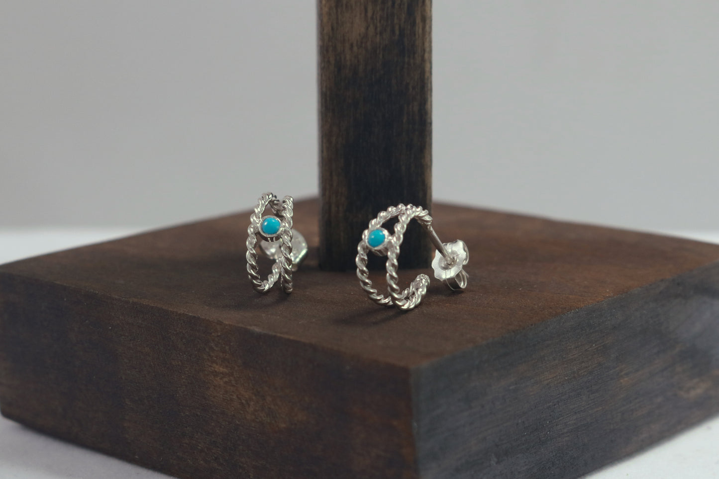 Small hoop huggie earrings made from 2 twisted sterling silver hoops with a round natural gemstone.