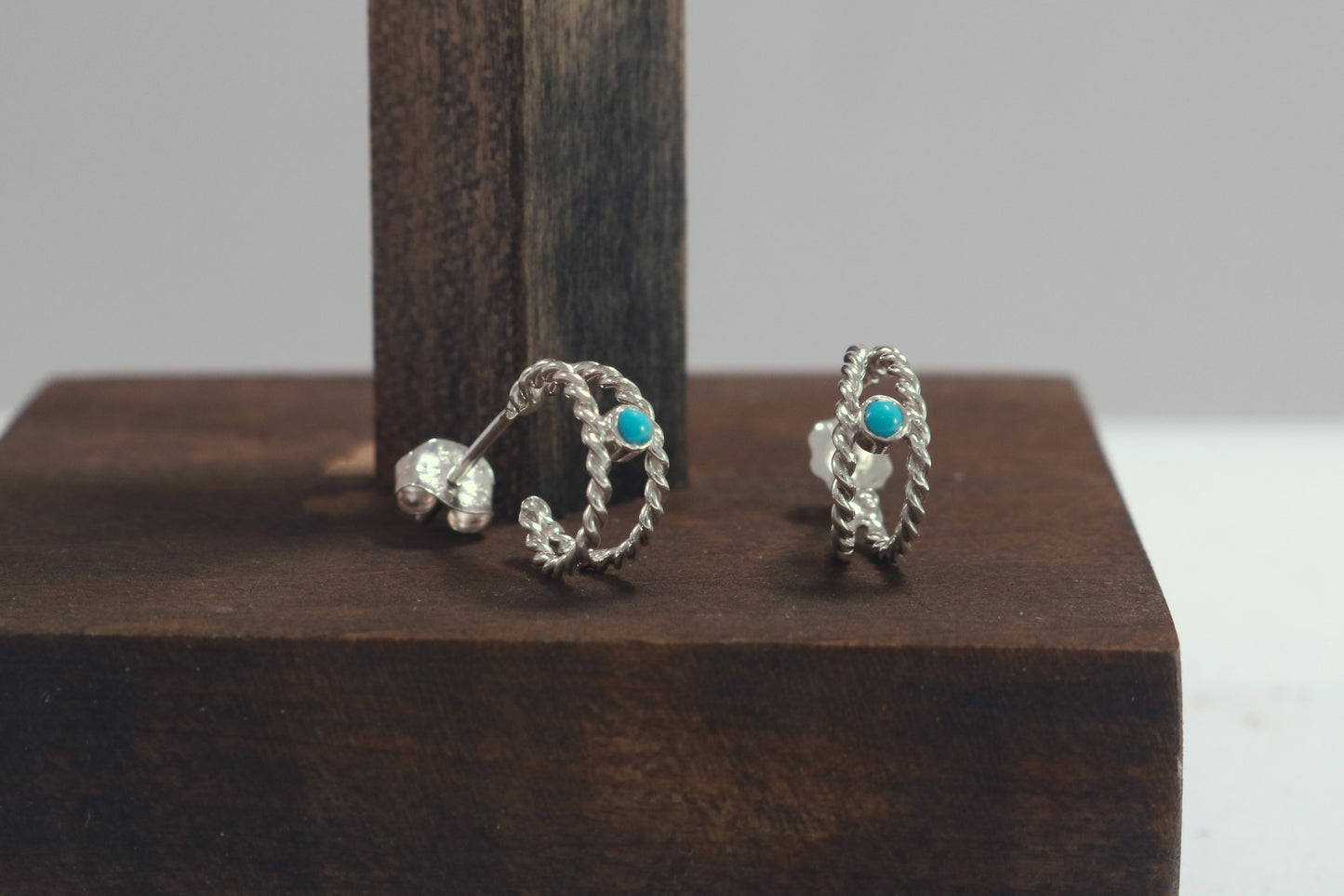 Small hoop huggie earrings made from 2 twisted sterling silver hoops with a round natural gemstone.