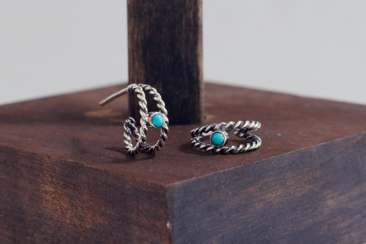 Small hoop huggie earrings made from 2 twisted sterling silver hoops with a round natural gemstone.