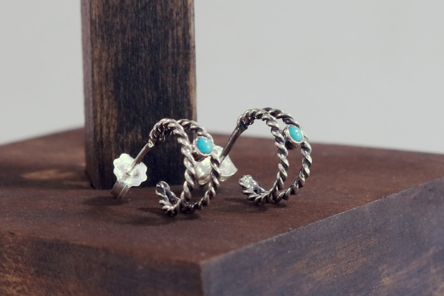 Small hoop huggie earrings made from 2 twisted sterling silver hoops with a round natural gemstone..