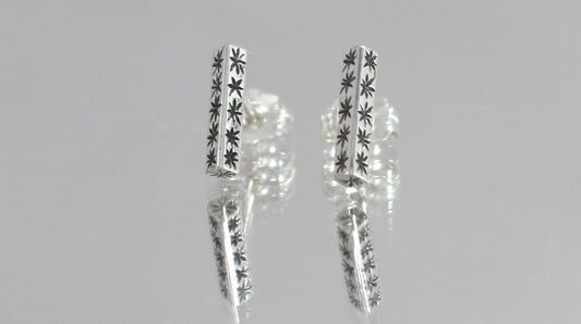 Sterling silver bar stud earrings with hand cut black stars.