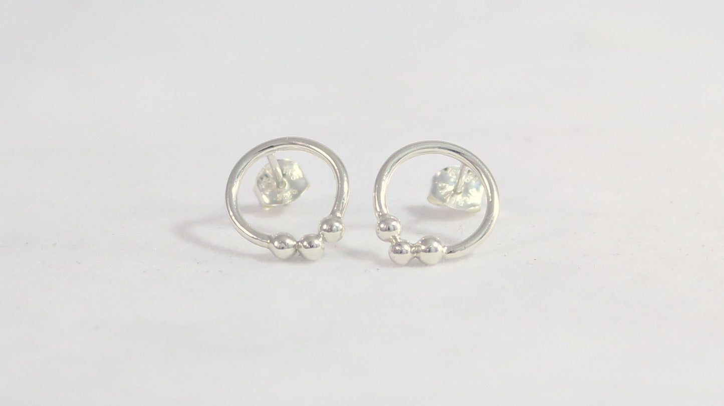 Sterling silver circle stud earrings with three silver bubbles at the bottom.