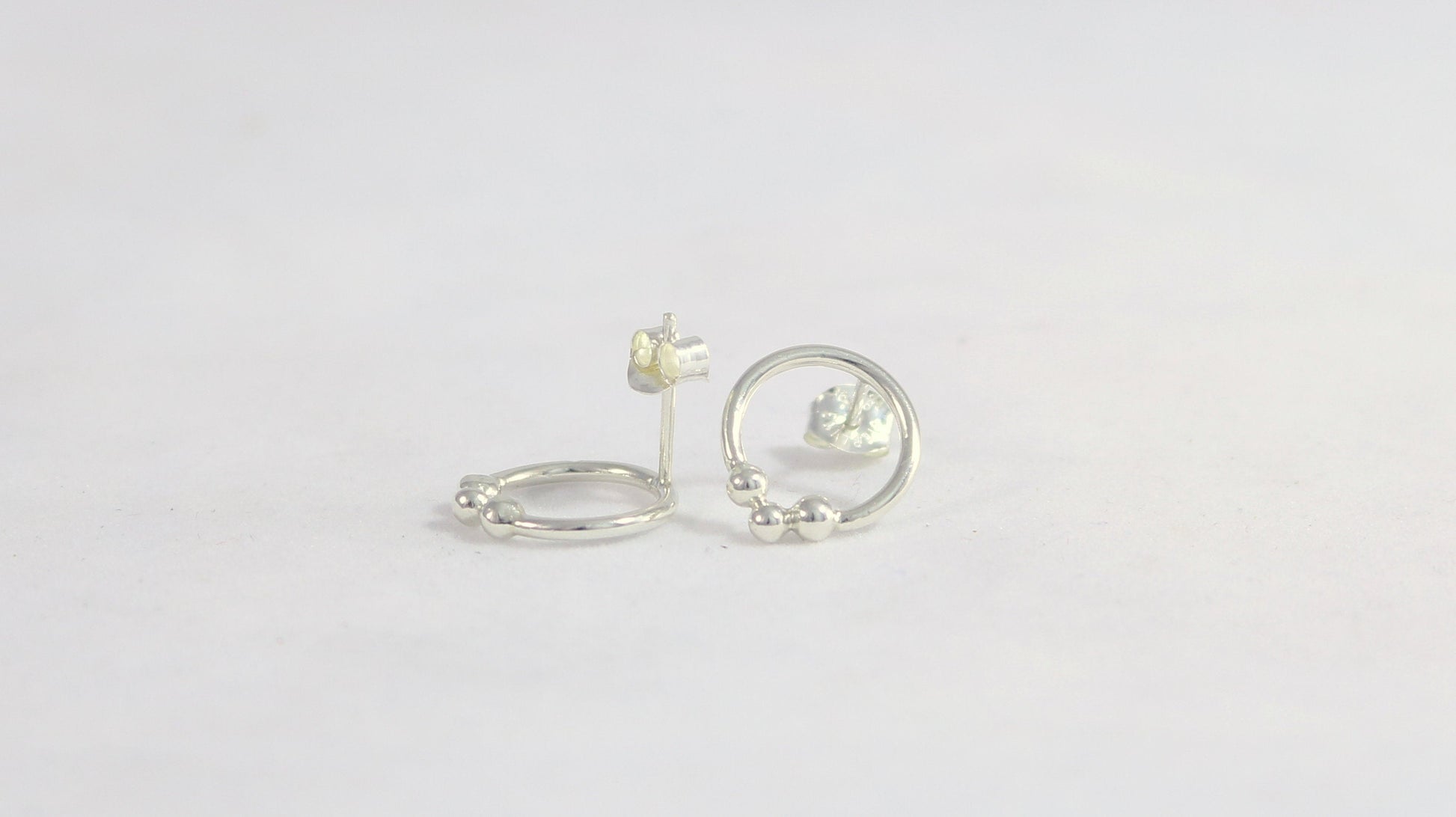 Sterling silver circle stud earrings with three silver bubbles at the bottom.