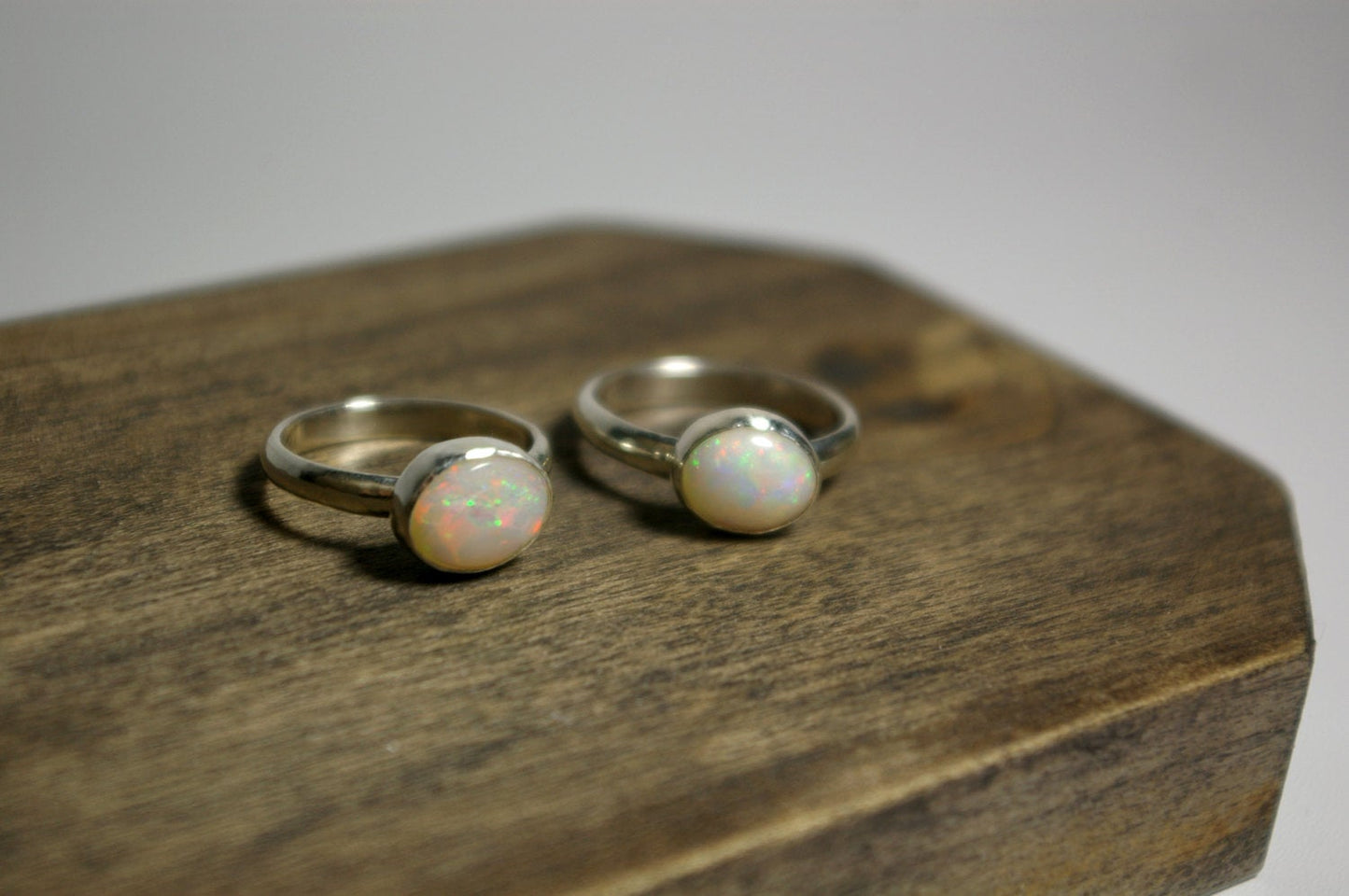 Oval natural white opal set in sterling silver bezel on a sterling silver ring band.