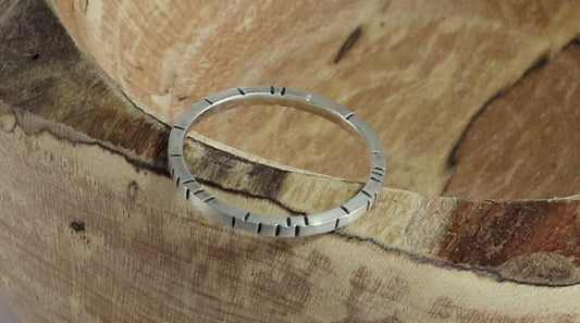 Sterling silver 1.5mm small stacking ring with randomly spaced black lines on all sides.