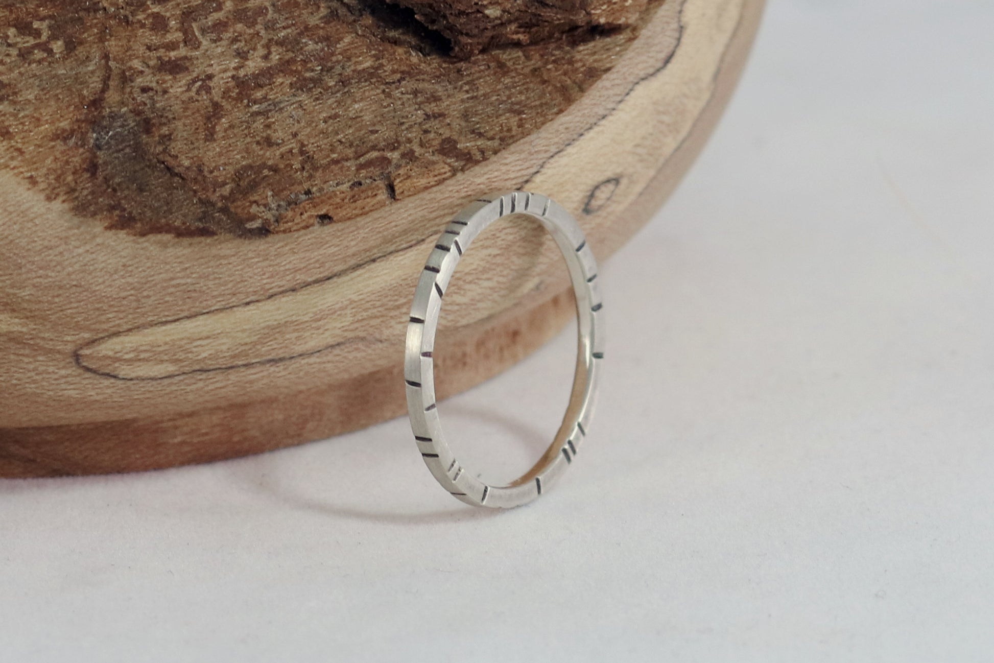 Sterling silver 1.5mm small stacking ring with randomly spaced black lines on all sides.