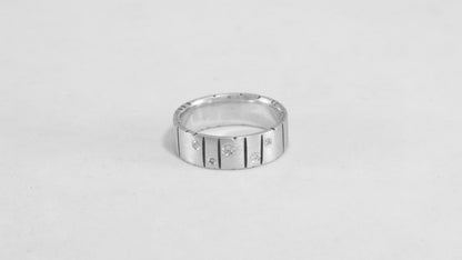 A thick silver ring band with randomly spaced black line details is flush set with 5 various sized diamonds.