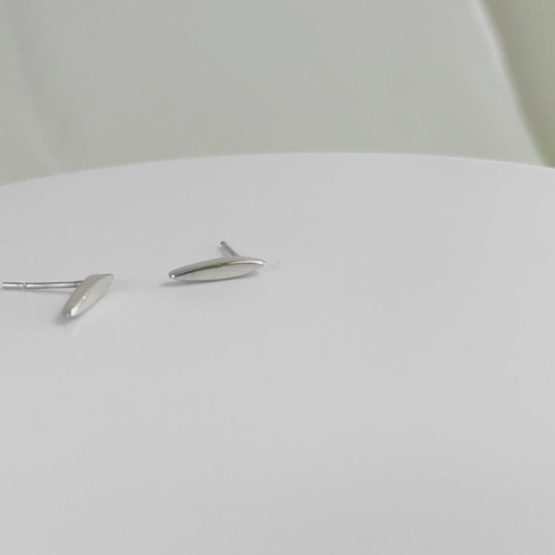 A video of studs made from solid sterling silver, shaped like a pointed ellipse.