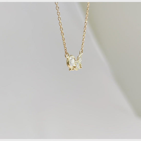 A video of three diamonds of descending size are set in 14k yellow gold bezels with little bubble clusters at the bottoms.