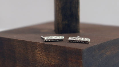 Sterling silver bar stud earrings with hand cut black stars.