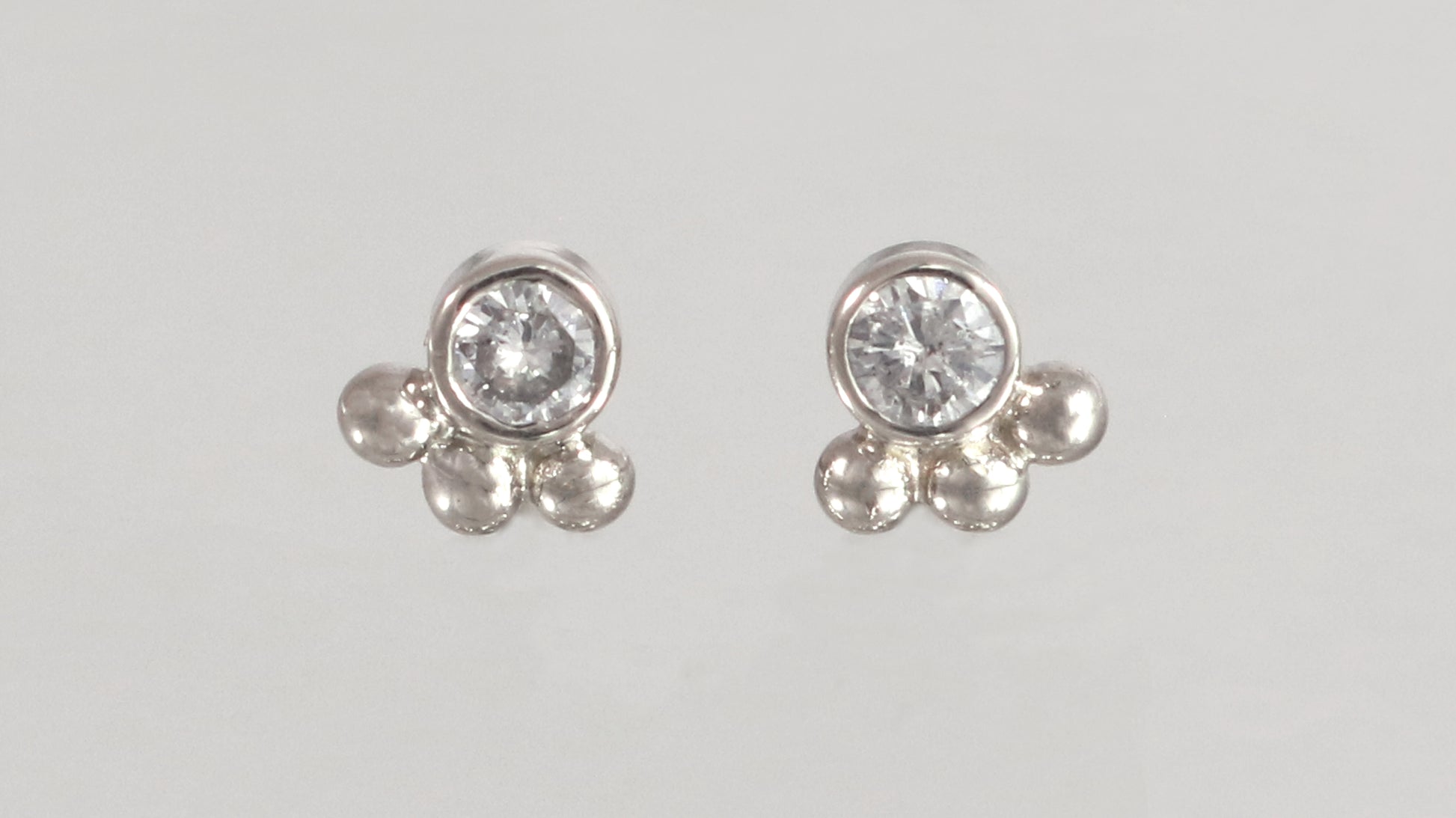 Studs with 3mm white diamonds set in 14k white gold with 3 bubbles in a group at the bottom.