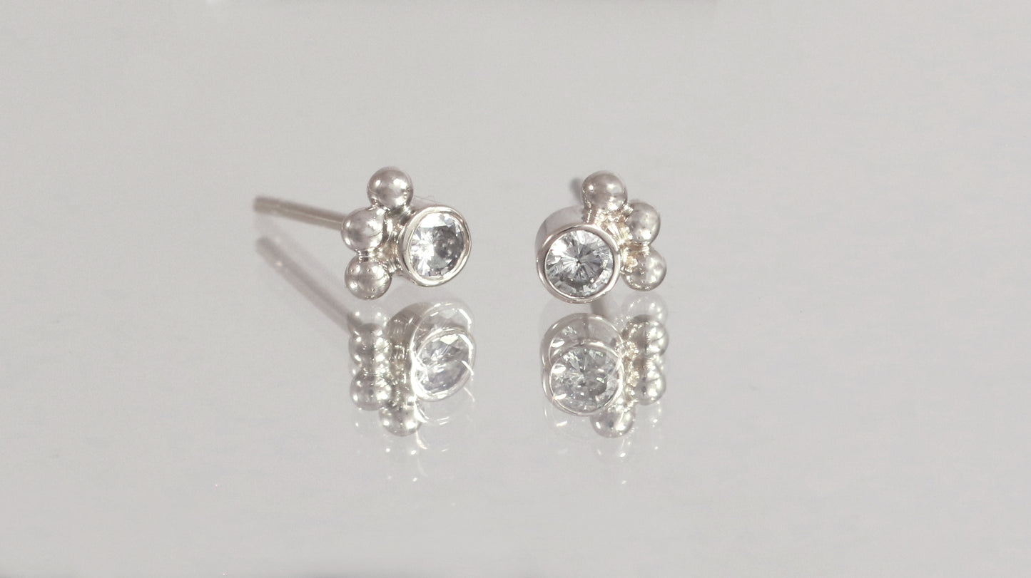 Studs with 3mm white diamonds set in 14k white gold with 3 bubbles in a group at the bottom.