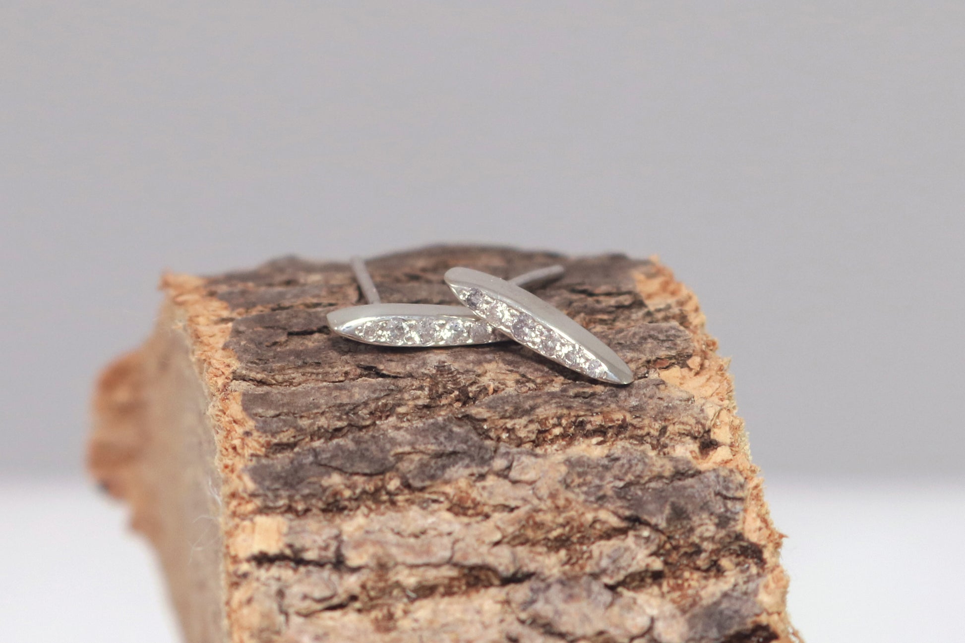 Studs made from solid sterling silver, shaped like a pointed ellipse, bead set with 6 diamonds descending in size.