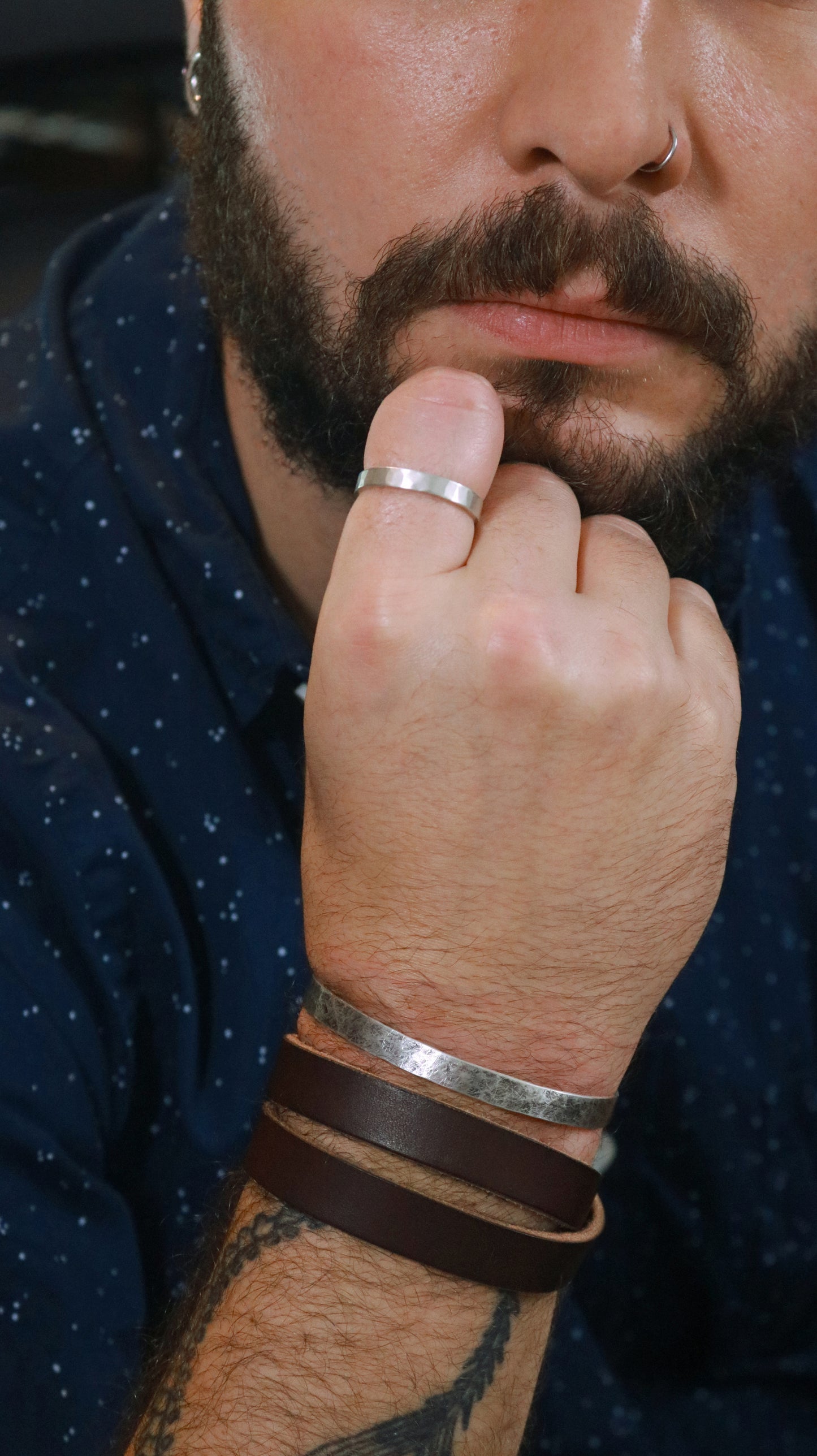 Bearded model wearing a 6mm sterling silver cuff with a weathered texture.