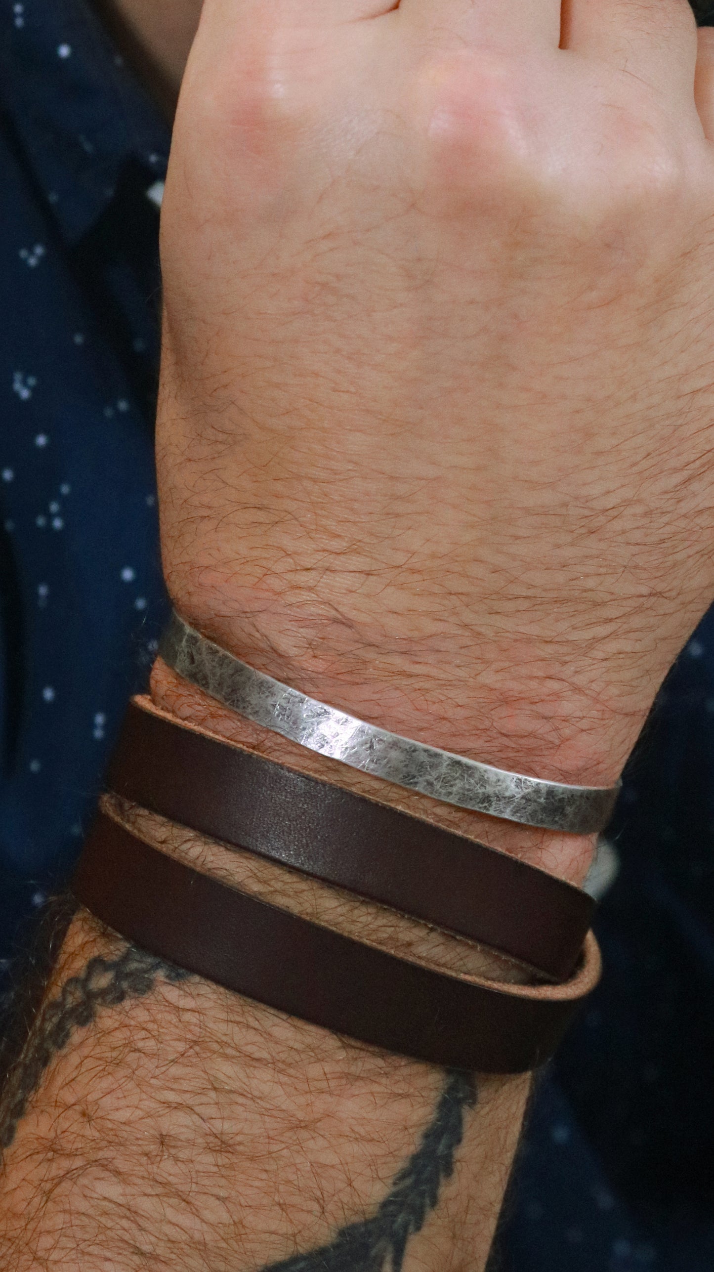 A model wearing a 6mm sterling silver cuff with a weathered texture.