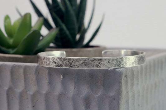 A 6mm sterling silver cuff with a weathered texture.