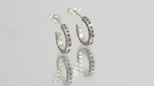 2mm sterling silver hoop huggie earrings with hand cut black stars.