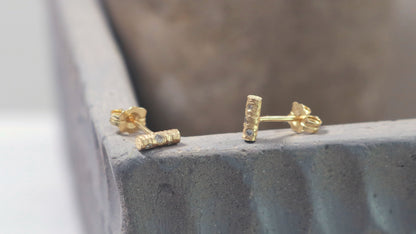 Solid 14k gold bar studs, textured and set with 3 diamonds in each.