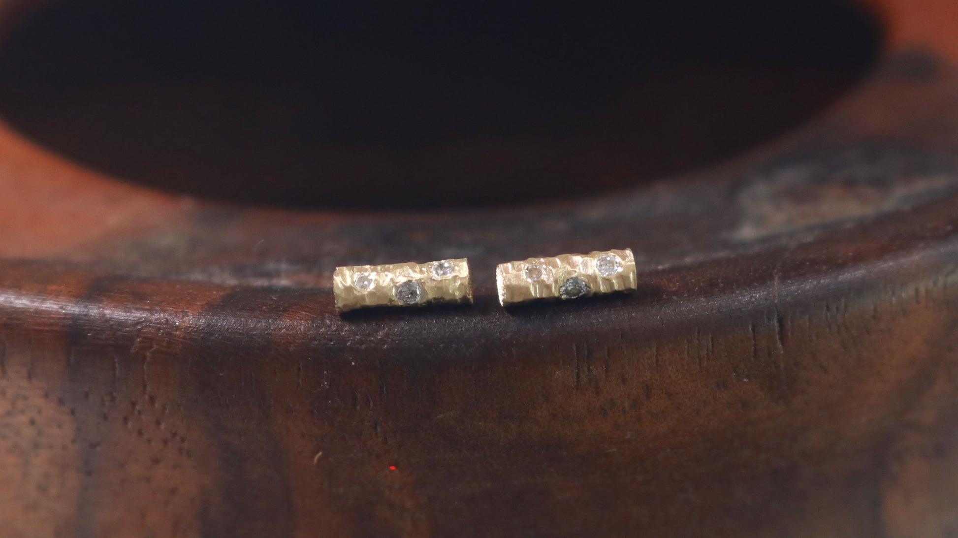 Solid 14k gold bar studs, textured and set with 3 diamonds in each.