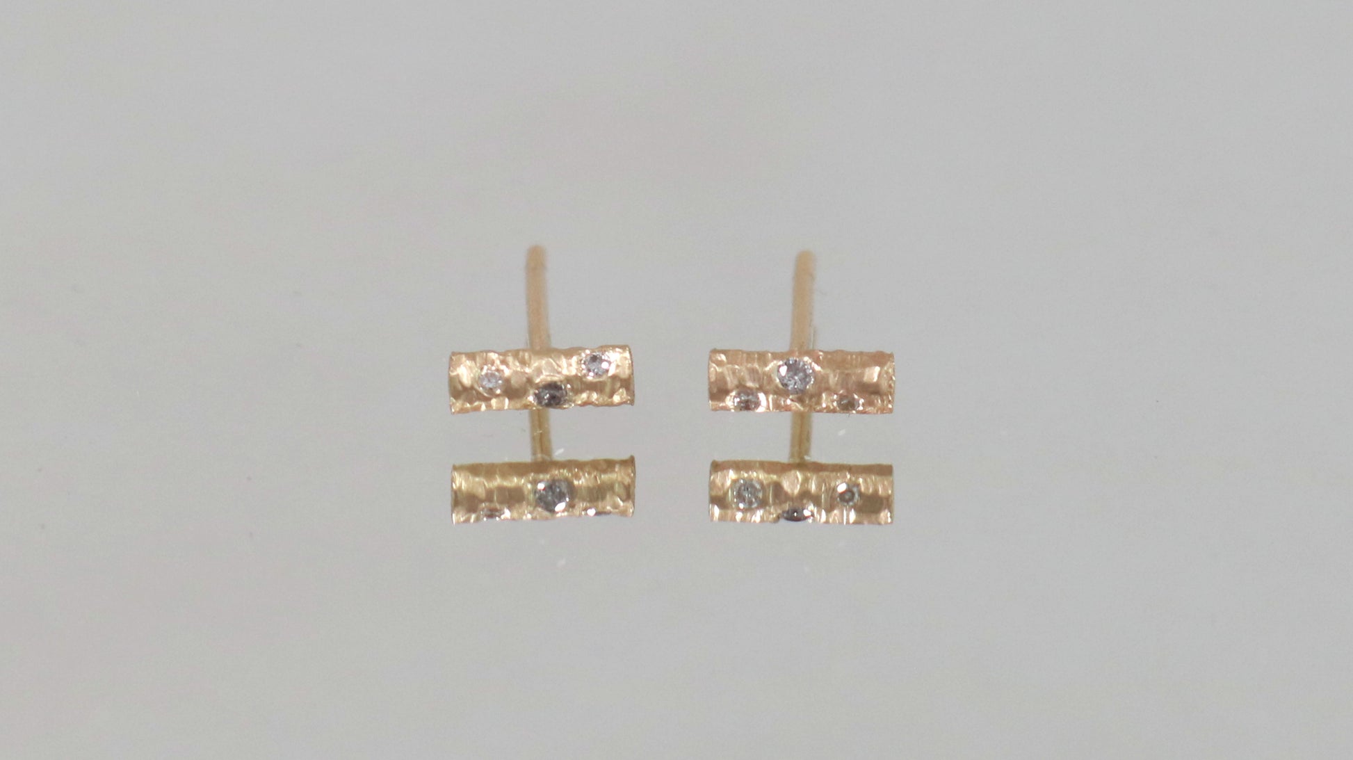 Solid 14k gold bar studs, textured and set with 3 diamonds in each.