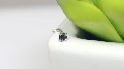 A basket set faceted blue sapphire nose stud made from 14k white gold.