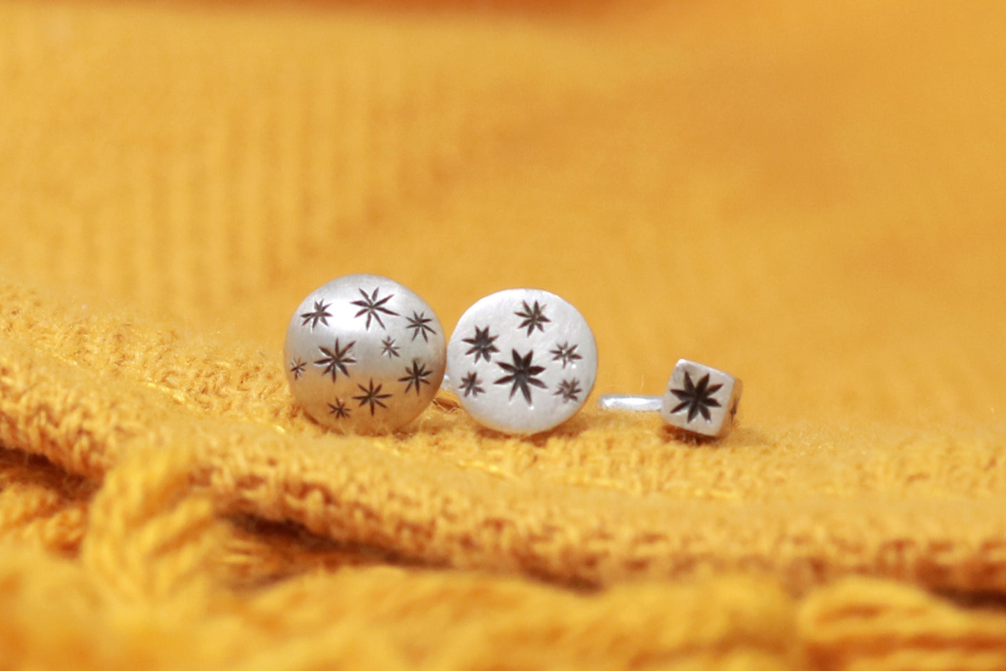 A 5mm domed, silver, nose stud with hand carved black stars.