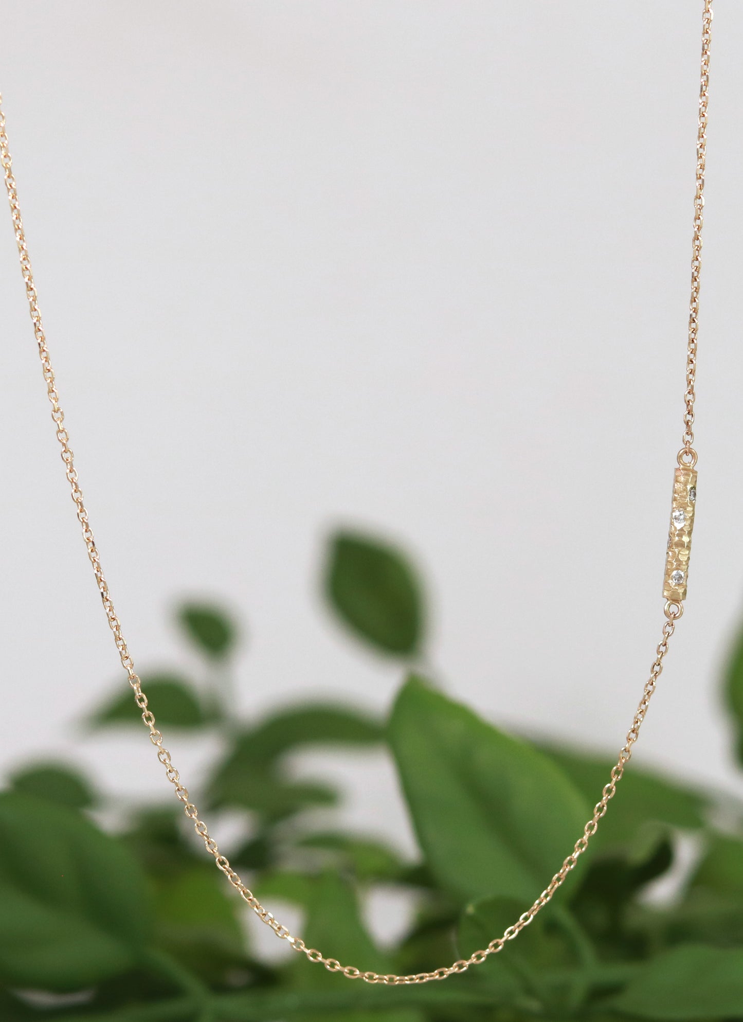 Solid 14k gold bar necklace, textured and set with 6 diamonds.