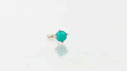 A 14k white gold nose stud with a round chrysocolla, set in prongs.