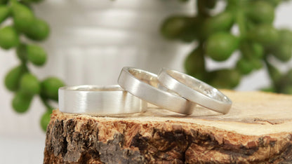 A group of various thickness sterling silver ring bands with a matte finish outside & polished finish inside.