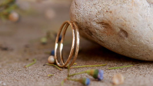 Thin yellow gold stacking rings with a hammer texture.