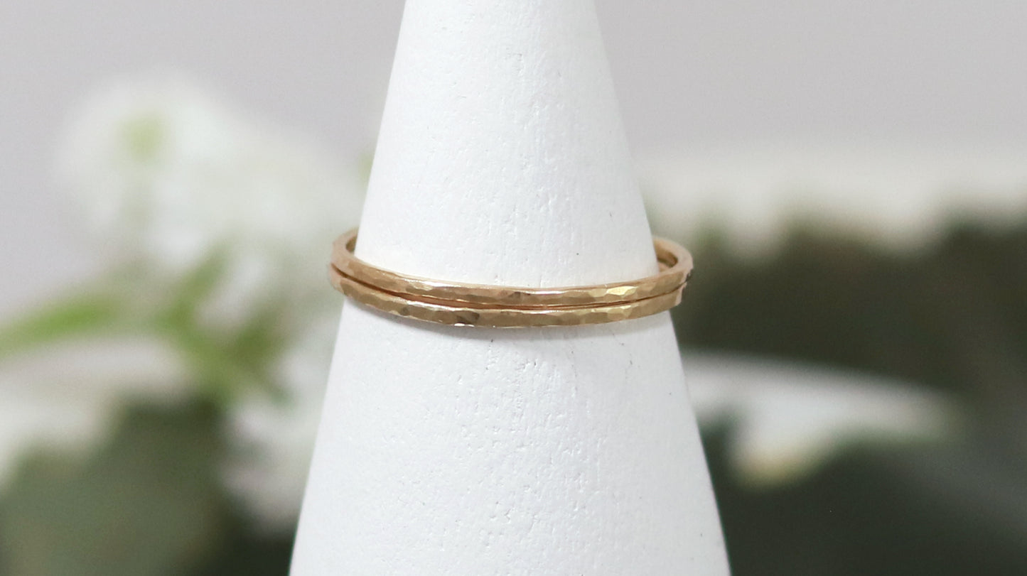 Thin yellow gold stacking rings with a hammer texture.